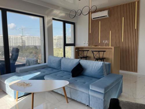 a living room with a blue couch and a table at Shiba studio Mamaia in Mamaia