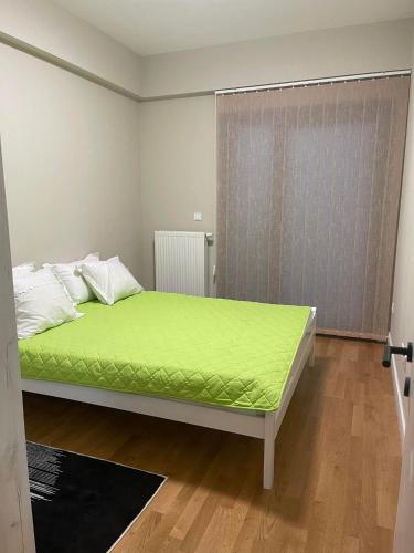 Schlafzimmer mit einem Bett mit grüner Matratze in der Unterkunft Diamond one skopje NJ in Skopje