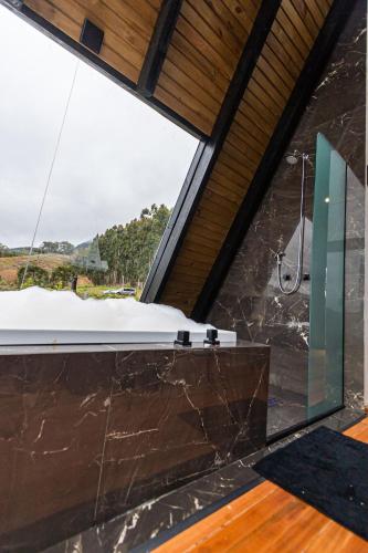 a bathroom with a large window and a shower at Chalé do Canyon in Alfredo Wagner