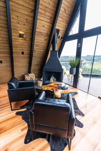 a room with a table and chairs and a fireplace at Chalé do Canyon in Alfredo Wagner