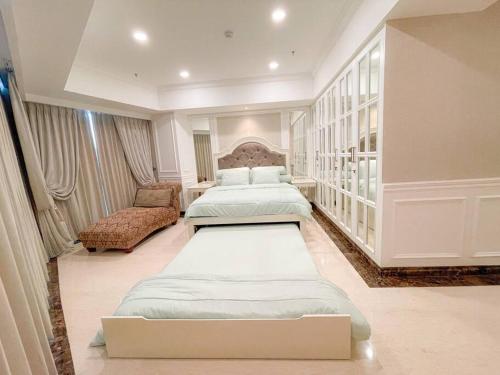 a large bedroom with two beds and a couch at The Jewel of La Casa III in Surabaya