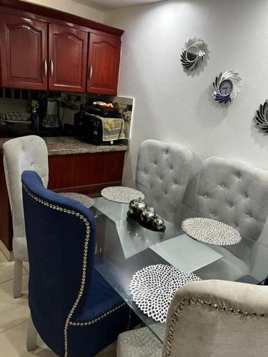comedor con mesa de cristal y sillas en Apartamento de 2 habitaciones con inversor y seguridad 24/7 en Villa Mella