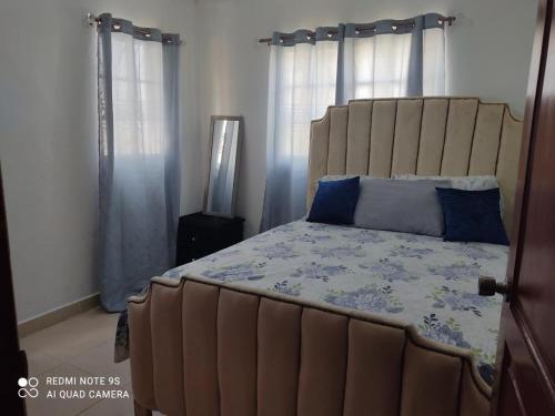 1 dormitorio con 1 cama grande con almohadas azules en Apartamento de 2 habitaciones con inversor y seguridad 24/7 en Villa Mella