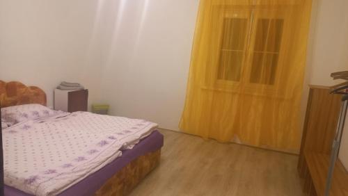 1 dormitorio con cama y cortina amarilla en Skromné ubytování v soukromí en Cheb