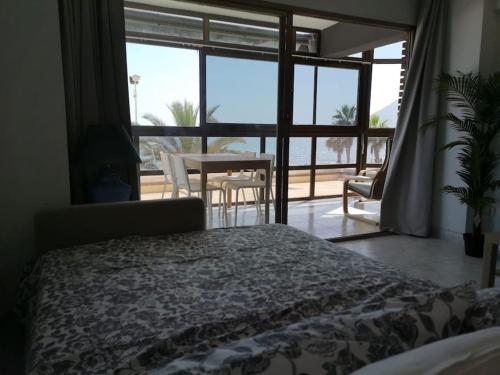 een slaapkamer met een bed en een groot raam bij Panoramic Sea Views in Calpe