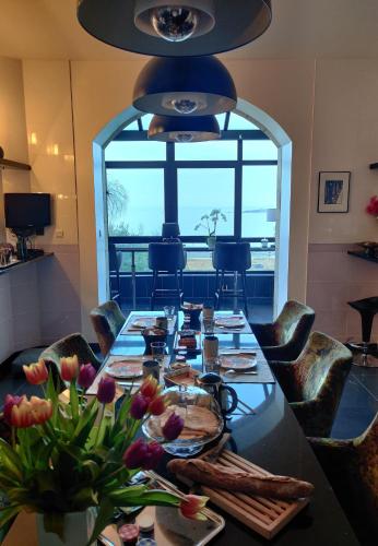- une salle à manger avec une grande table fleurie dans l'établissement Château de Saint-Samson, à Plougasnou