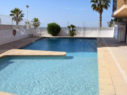 a large blue swimming pool with the ocean in the background at Panoramic Sea Views in Calpe