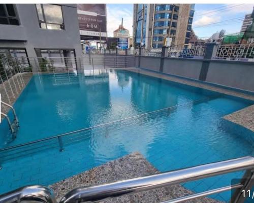 - une piscine bleue au-dessus d'un bâtiment dans l'établissement Staroot residency Nairobi, à Nairobi