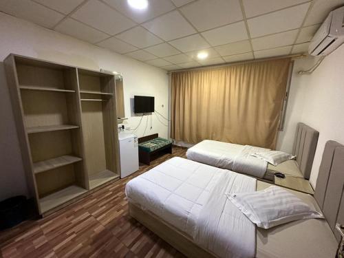 ein Schlafzimmer mit 2 Betten und einem TV in der Unterkunft فندق الروان 