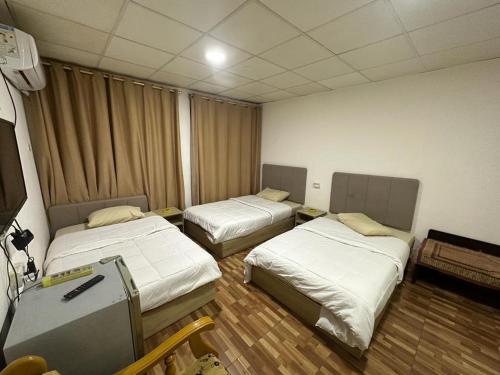 ein Zimmer mit 2 Betten und einem Koffer darin in der Unterkunft فندق الروان 