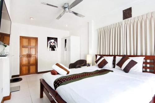 a bedroom with a large white bed with a ceiling fan at 5 Bedroom Villa in Fisherman’s Village in Bophut 