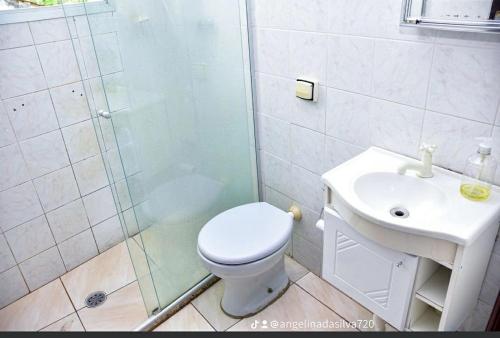 a bathroom with a shower and a toilet and a sink at Apartamento Praia Mongagua in Mongaguá