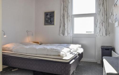 スナーヴィグにある3 Bedroom Nice Home In Ringkbingのベッドルーム1室(白いシーツ付きのベッド1台、窓付)