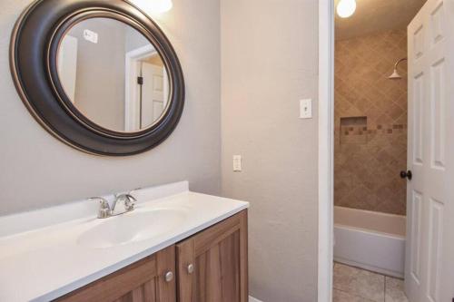 a bathroom with a sink and a mirror and a tub at 4BR Family Getaway, Pets Welcome, Self Check In! in Humble
