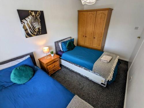 a bedroom with two beds and a zebra picture on the wall at Hs UK Homes Beautiful 2 bed in Bradford in Bradford