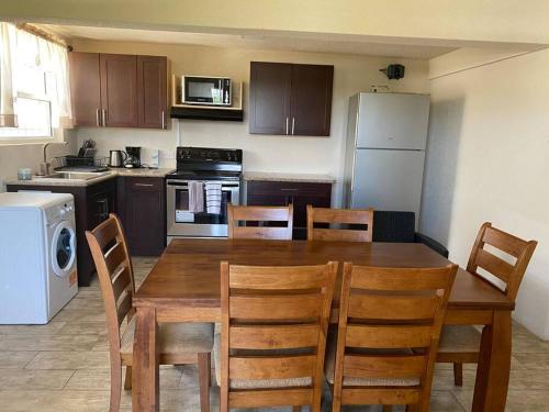 a kitchen with a wooden dining table and chairs at SkylineSuites Lost in Paradise - FA3 in Grand Anse