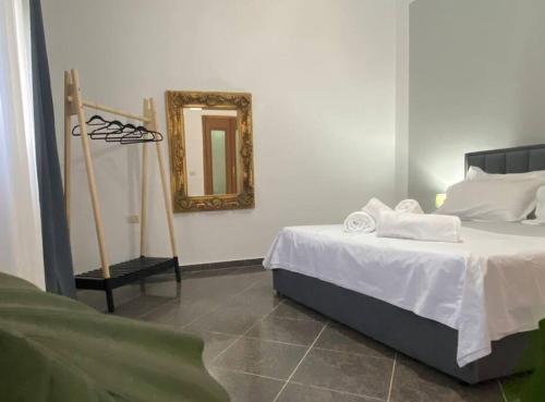 - une chambre avec un lit et un miroir mural dans l'établissement Cosy, private apartment in a family villa, à Tirana