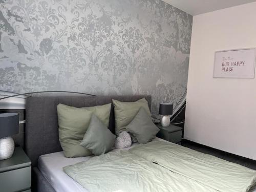 a bedroom with a bed with a gray wall at City Vibe Zentrum Zwickau in Zwickau
