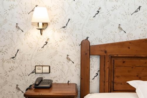 a bedroom with a bed and a phone on a table at Hotel Restaurante De Torres in Felechosa