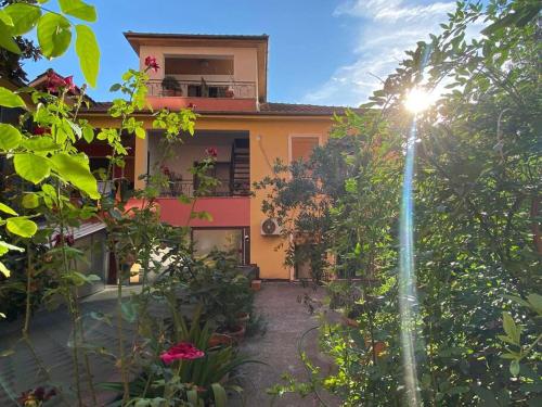 une maison où le soleil brille à travers les arbres dans l'établissement Cosy, private apartment in a family villa, à Tirana