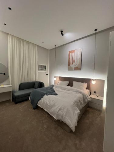 1 dormitorio con 1 cama grande y 1 sofá en سكون الفاخرة - دخول ذاتي, en As Sayl aş Şaghīr