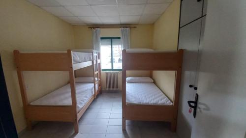 um quarto com 2 beliches num quarto em Albergue de Villamanín em Villamanín