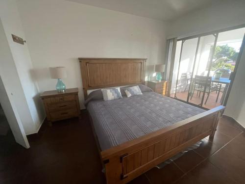 a bedroom with a large wooden bed and a balcony at Your cozy home @Rosarito in Rosarito