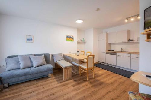 a living room with a couch and a table and a kitchen at Haus Hubertus in Mieders