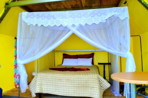 a bedroom with a bed with a canopy at Mundo Abu San Juan La laguna in San Juan La Laguna