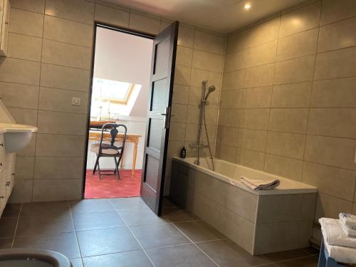 uma casa de banho com uma banheira e uma cadeira em Maison bonheur proche GIVERNY et top pour télétravail 