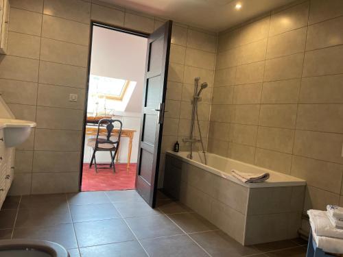 a bathroom with a tub and a chair at Maison bonheur proche GIVERNY et top pour télétravail in Haute-Isle