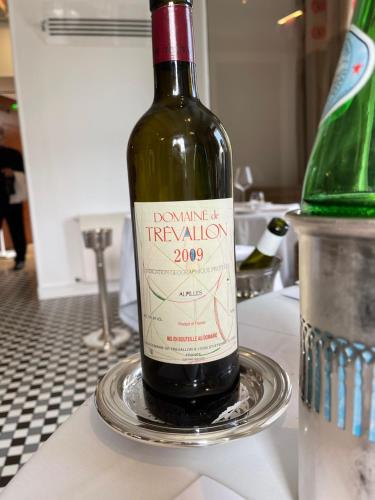 une bouteille de vin assise sur une assiette sur un comptoir dans l'établissement Maison bonheur proche GIVERNY et top pour télétravail, à Haute-Isle