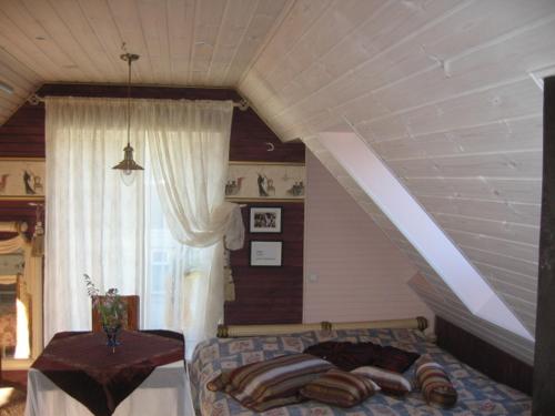 uma sala de estar com uma cama e uma janela em MaaRitza Holiday Cottage em Türi