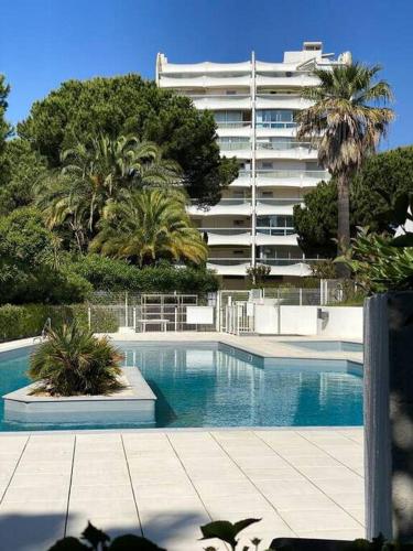 une piscine devant un grand immeuble dans l'établissement Appartement La Pergola, à La Grande Motte
