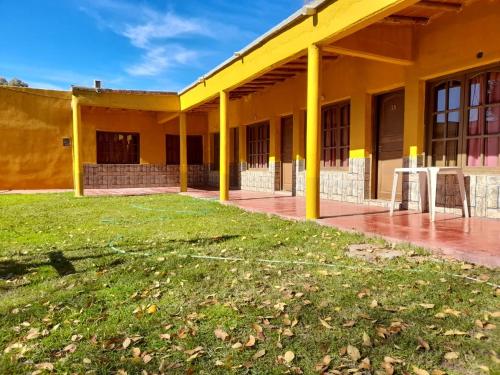een geel gebouw met een groen gazon ervoor bij Fatme Hotel in San Agustín de Valle Fértil
