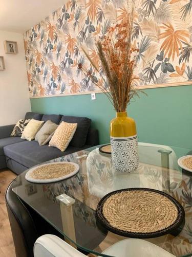 - un salon avec une table en verre et un vase dans l'établissement Aubervilliers Paris, à Aubervilliers