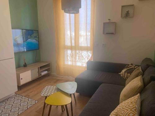 a living room with a couch and a tv at Aubervilliers JO Paris in Aubervilliers