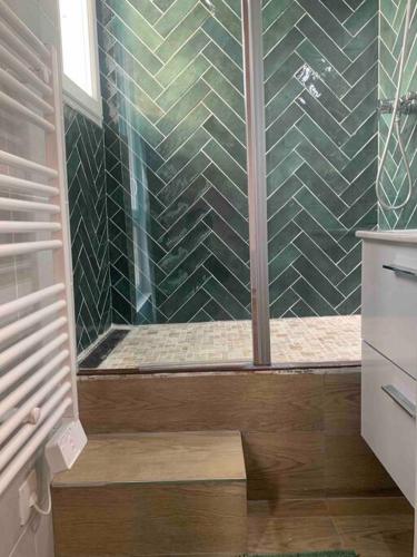 une salle de bain avec une douche avec une porte vitrée dans l'établissement Aubervilliers Paris, à Aubervilliers