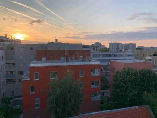 a sunset in a city with a red brick building at Aubervilliers JO Paris in Aubervilliers