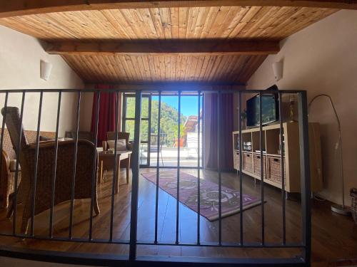 a living room with a television and a balcony at Iconic Italian Townhouse w Rooftop Terrace & Mountain View, Pigna in Pigna
