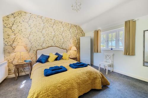 a bedroom with a yellow bed with blue pillows at Stable Cottage in Dorchester