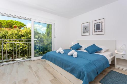a bedroom with two beds and a large window at Holiday house Bibi in Punat