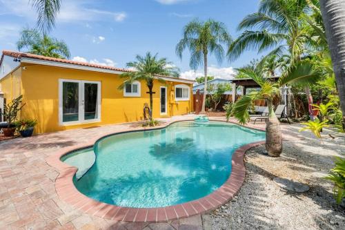 a swimming pool in front of a house at Tropical Paradise in Fort Lauderdale
