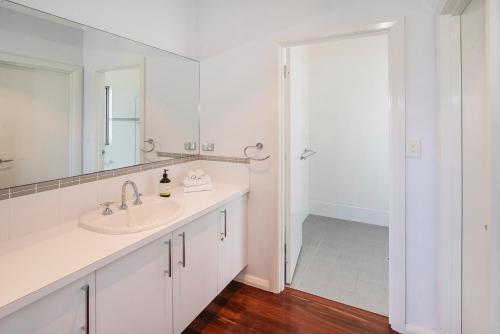 a white bathroom with a sink and a shower at Cantley at Flutes Estate, Margaret River in Wilyabrup