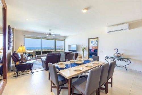 a dining room and living room with a table and chairs at Hermosa vista al Arco de Cabo in Cabo San Lucas