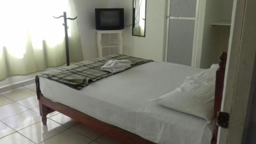 un letto bianco in una camera con TV di HOTEL CASA DEL REY!! a Arriaga