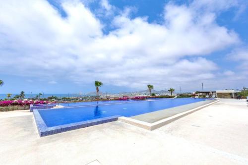 a large swimming pool with the ocean in the background at Hermosa vista al Arco de Cabo in Cabo San Lucas