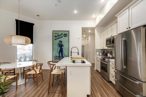 a kitchen with white cabinets and a table with chairs at The Lumber Baron's Mansion: 2 King Suites, 2.5BA + Gym in Detroit