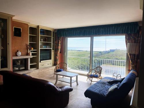 a living room with a couch and a large window at gavres-port-louis-ocean in Gâvres
