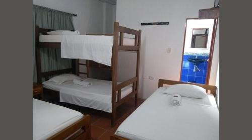 a room with three bunk beds and a mirror at Hotel Mompox - Hotel Santa Cruz Mompos - Hotel Mompos in Mompós